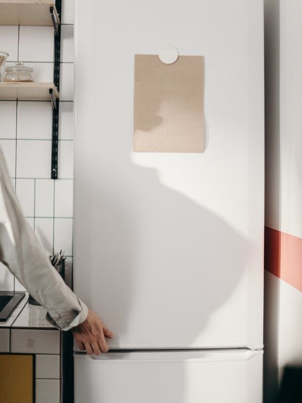 A hand holding refrigerator door